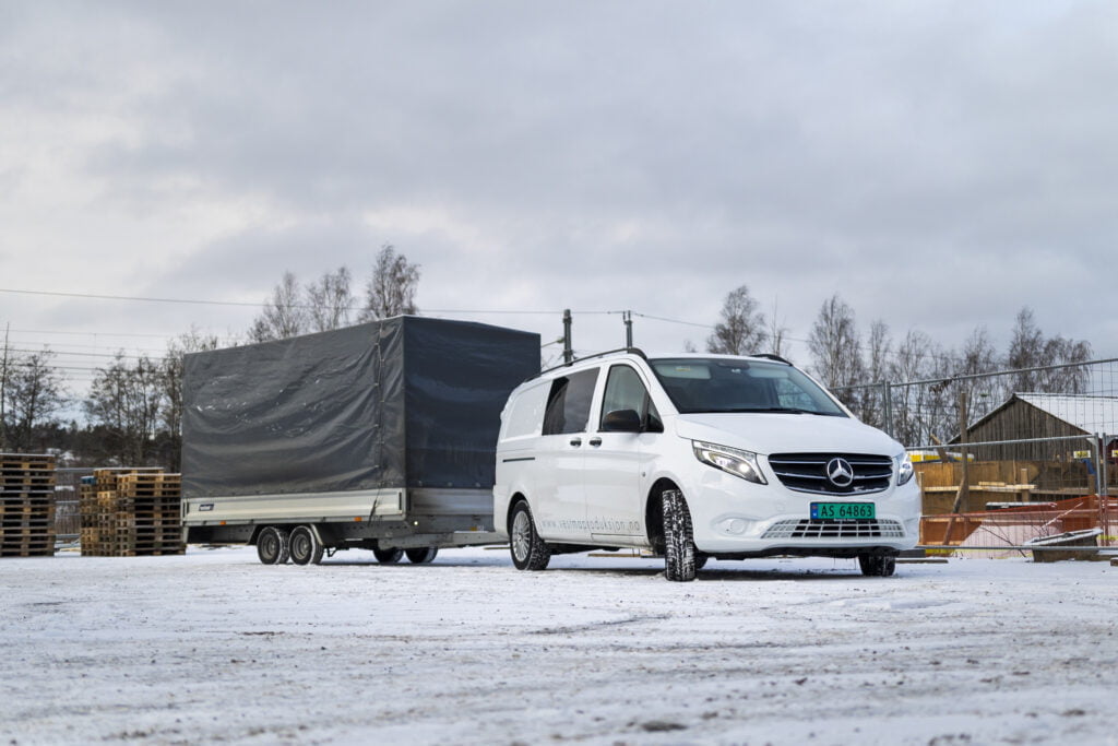 Vestma Produksjons hvite Mercedes varebil og tilhenger i grått vær.